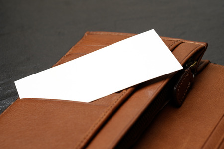 blank name card or business card in brown leather wallet on black granite blackgroundの写真素材