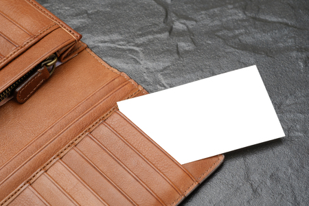 blank name card or business card in brown leather wallet on black granite blackgroundの写真素材
