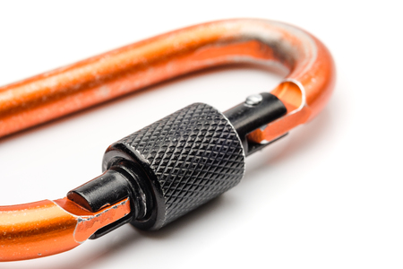 Close up black locking of orange Carabiner on white backgroundの写真素材