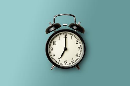 black vintage alarm clock on green color backgroundの写真素材
