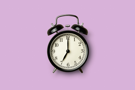 black vintage alarm clock on purple color backgroundの写真素材
