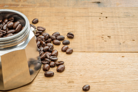 coffee beans in a moka pot on wooden tableの写真素材