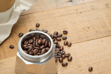 coffee beans in a moka pot on wooden tableの写真素材
