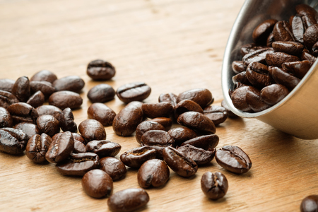 coffee beans on wooden table and in funnel of moka potの写真素材