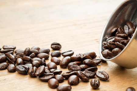 coffee beans on wooden table and in funnel of moka potの写真素材