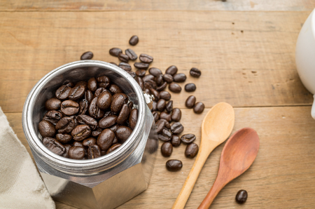 coffee beans in a moka pot on wooden tableの写真素材