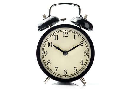 black vintage alarm clock isolated on white background with reflect on floorの写真素材