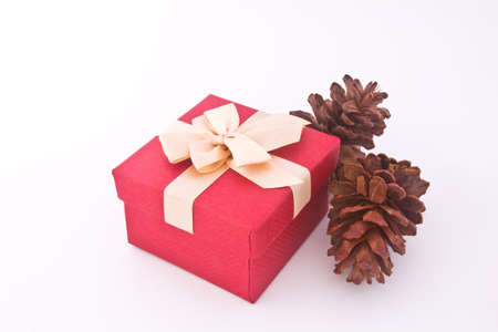 Christmas gift box and pine cones over white backgroundの写真素材