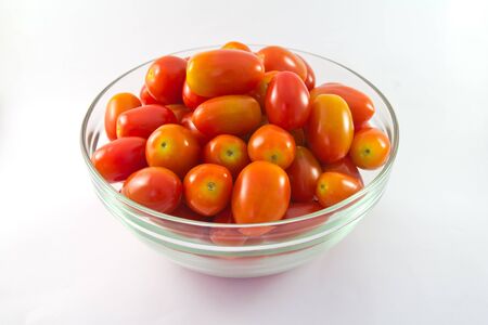 baby tomatoes in glass bowl on white backgroundの写真素材