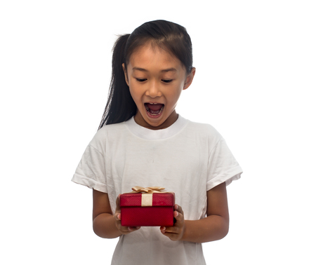 Happy Asian child girl with red gift box for Christmas themeの写真素材
