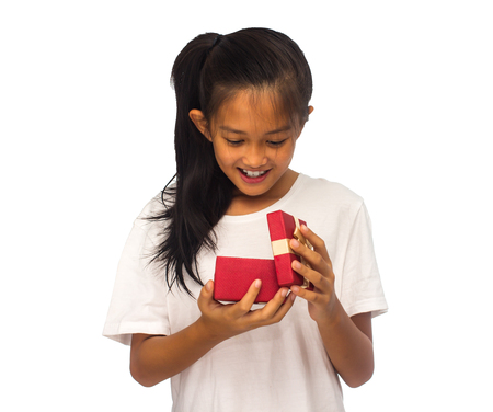 Happy Asian child girl with red gift box for Christmas themeの写真素材