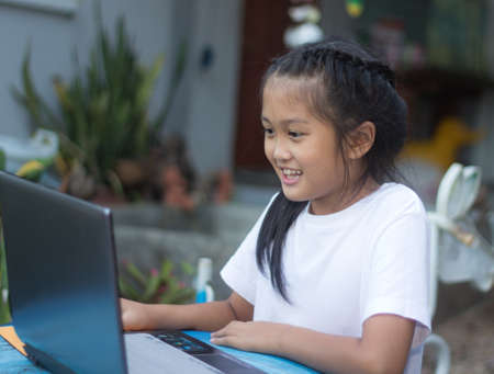 Cute little asian girl using laptopの写真素材