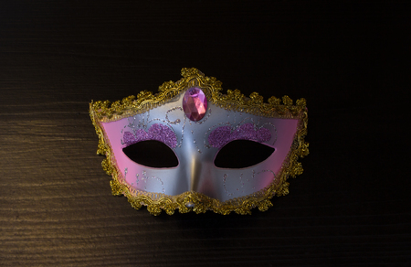 Carnival mask on black wooden background with night lightの写真素材