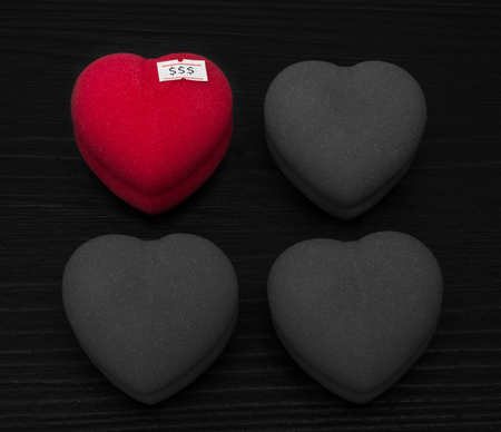 Heart for sale or Love for sale. Red heart shape with sale price tag on black board backgroundの写真素材