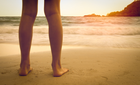 legs on the beach in the sunsetの写真素材