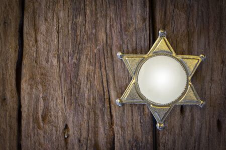 Wild West Sheriff badge on wood backgroundの写真素材
