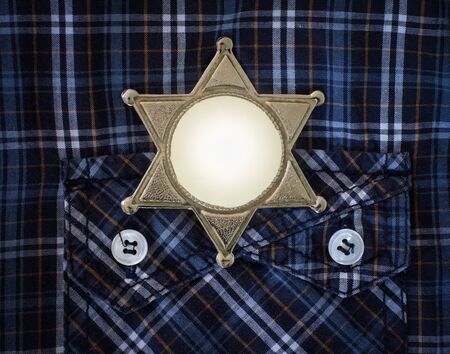 Wild West Sheriff badge on cowboy shirt backgroundの写真素材