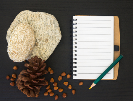 top view image of open blank notebook on black wooden table and nature decorationの写真素材
