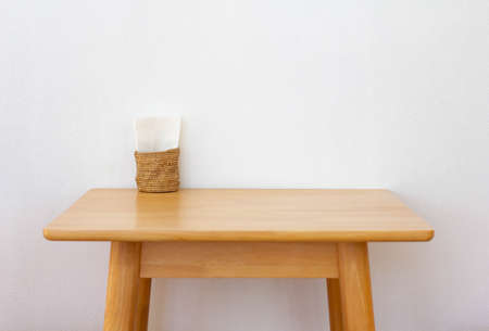 Wooden desk for work space with blank paper in basket.