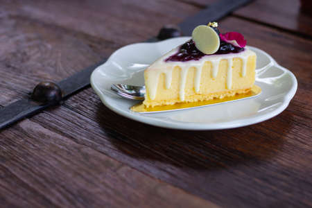 Piece of sponge cake decorate in white plat set on wooden tableの写真素材