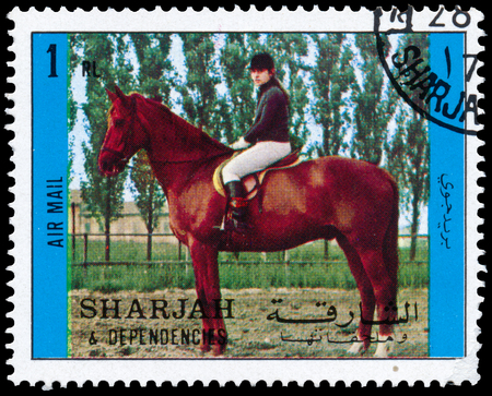 BUDAPEST, HUNGARY - 02 NOVEMBER 2015: a stamp printed in Sharjah shows person sits on a horse, circa 1972のeditorial素材