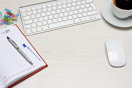 Office table with notepad, computer and coffee cup. View from above with copy space.の写真素材