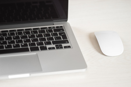 Laptop on a light table with a mouseの写真素材