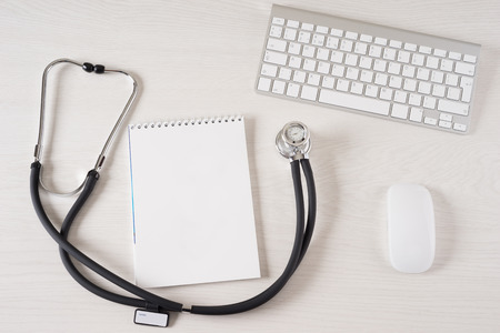 Stethoscope on doctor's desk with keyboard and padの写真素材