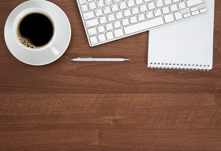 View from above with copy space, office table with notepad, keyboard and coffee cup.の写真素材