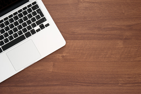 Laptop computer on a wooden desk, top view copy spaceの写真素材
