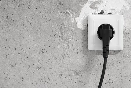 Energy, Electric Plug on a concrete wallの写真素材