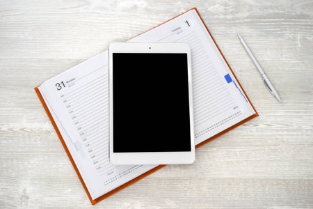 Digital tablet on a light table with a notebookの写真素材