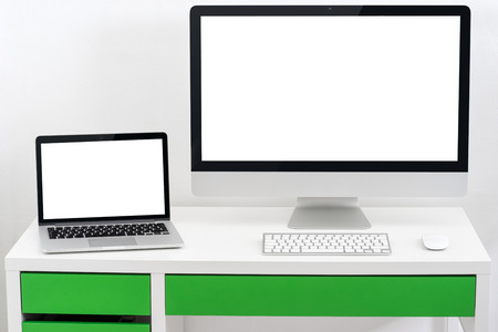 The computer and laptop on the white desk isolatedの写真素材
