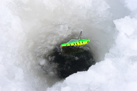 Ice hole drilled in the ice ready for fishing on iceの写真素材