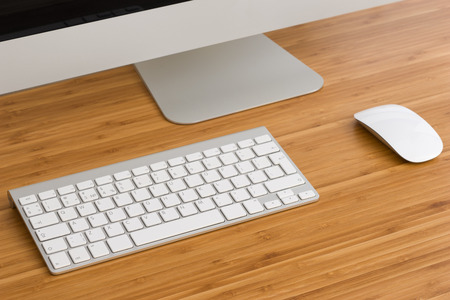 A computer with a keyboard and mouse on the Desk in the officeの写真素材