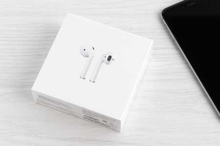 UFA, RUSSIA - OCTOBER 18, 2017: AirPods wireless headphones developed by Apple Inc. AirPods is on the box and iphone.のeditorial素材