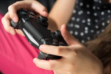 UFA, RUSSIA - NOVEMBER 12, 2017: Hand girl playing Sony Dualshock 4 controller for PlayStation 4 pro. Sony PlayStation 4 pro game console of the eighth generation.のeditorial素材