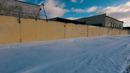 Old Soviet prison in winter, high fence with barbed wire and snowの写真素材