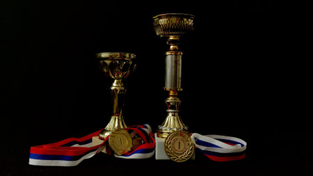Gold, silver, bronze medals and cups on a black background. A large number of significant awards for performances in front of people and high-level sporting achievementsの写真素材