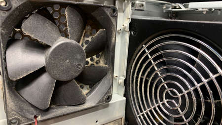 An old computer covered with dust is dismantled in a workshop for fixing broken equipment