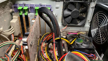 An old computer covered with dust is dismantled in a workshop for fixing broken equipment
