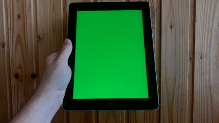 Chroma key on electronic devices, phone and monitor, green screen and hand scrolling through the screen in the absence of lightの写真素材