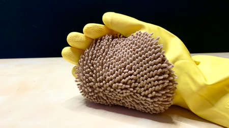 Woman in rubber cleaning gloves prepares to clean up her house using sponges, rags and cleaning productsの写真素材