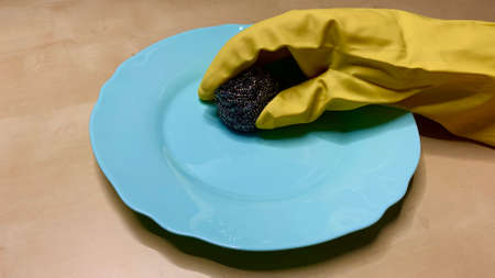 Woman in rubber cleaning gloves prepares to clean up her house using sponges, rags and cleaning productsの写真素材