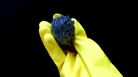 Woman in rubber cleaning gloves prepares to clean up her house using sponges, rags and cleaning productsの写真素材