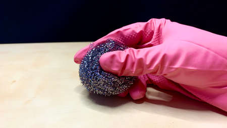 Woman in rubber cleaning gloves prepares to clean up her house using sponges, rags and cleaning productsの写真素材
