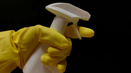 Woman in rubber cleaning gloves prepares to clean up her house using sponges, rags and cleaning productsの写真素材