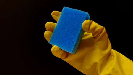 Woman in rubber cleaning gloves prepares to clean up her house using sponges, rags and cleaning productsの写真素材