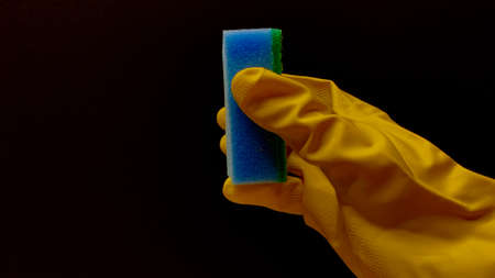 Woman in rubber cleaning gloves prepares to clean up her house using sponges, rags and cleaning productsの写真素材