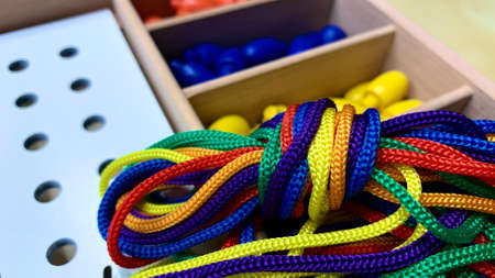 Children's game for the development of fine motor skills with colored laces and holes for tying